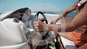 skippers hands turning steering wheel at sailing boat photo