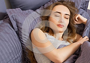 Closeup - Sleep. Young Woman Sleeping In Bed. Portrait Of Beautiful Female Resting On Comfortable Bed With Pillows In Bedding In