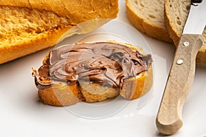 Closeup of a slice of loaf bread with chocolate paste spread on it