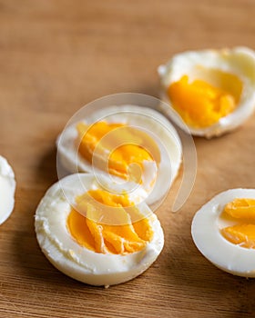 Closeup of sliced boiled eggs arranged neatly on a wooden cutting board