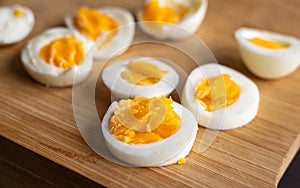 Closeup of sliced boiled eggs arranged neatly on a wooden cutting board