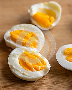 Closeup of sliced boiled eggs arranged neatly on a wooden cutting board