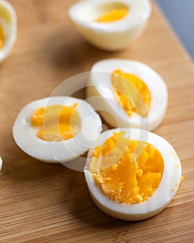 Closeup of sliced boiled eggs arranged neatly on a wooden cutting board