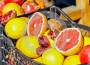 Closeup of sliced colorful fresh fruit, grapefruit and pomegranate at the streetmarket