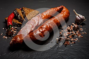 Closeup sliced dry smoked sausage with garlic, chili and rye bread