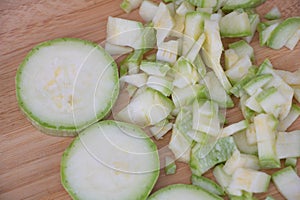 A closeup of sliced zucchini on the kitchen counter, with some being finely chopped and others half cut for cooking