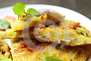 Closeup Slices of Spanish Omelet or Tortilla de Patatas Garnished with fresh Basil Leaves
