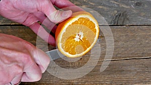 Closeup Of Slicing Orange On Wooden Desks