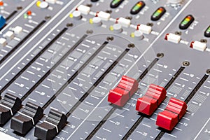 Closeup on sliders of sound mixing console in audio recording