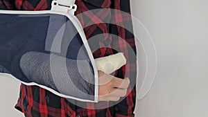 Closeup of sling on teenage man's broken arm to worn during rehabilitation