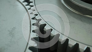 Closeup on slowly rotating iron metallic gears, 4k realistic 3d animation loop. Symbol of teamwork, industry or business.