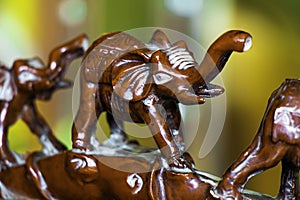 Closeup of small clay elephant figures under the lights with a blurry background