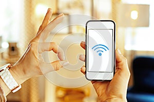 Closeup on smartphone with strong wifi signal in hand of woman photo