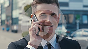 Closeup smiling business man talking mobile phone outdoors. Close up of cheerful businessman having phone call on office