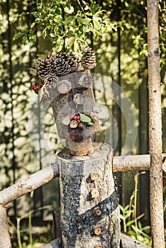 Closeup of a smiling character, possibly a farmer, made of wooden trunks and cones bears happiness and lightheartedness feeling photo
