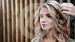 Closeup smiling face of young woman during creating hairstyle. Shot on RED Raven 4k Cinema Camera