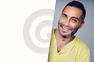 Closeup of smiling hispanic man holding blank white board with copy space for text