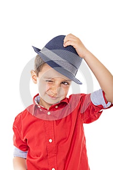 Closeup of a smiling little boy blinking holding a hat
