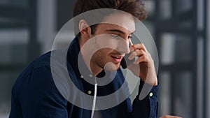 Closeup smiling man talking mobile in office. Cheerful guy having phone call