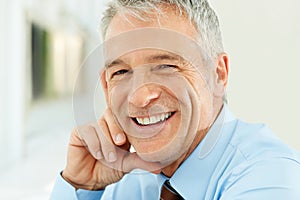 Closeup of smiling middle aged businessman. Closeup portrait of smiling middle aged businessman in office.