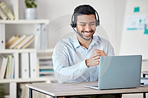 Closeup of smiling mixed race call centre agent smiling while wearing headset. Young male customer service