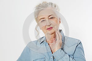 Closeup of smiling senior woman wrinkle face and gray hair. Old mature lady touching her wrinkled skin isolated on white