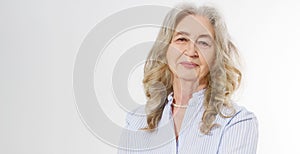 Closeup of smiling senior woman wrinkle face and gray hair. Old mature lady touching her wrinkled skin isolated on white