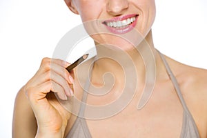 Closeup on smiling woman holding brown eye liner