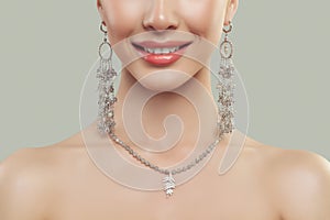 Closeup of smiling woman lips and fashion jewelry.