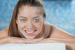 Closeup of smiling woman lying on stomach on couch in spa