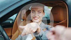 Closeup smiling woman sitting in new car. Happy woman getting keys from new car