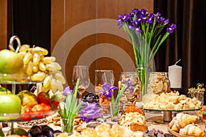 Closeup snacks, fresh and dried fruits, pieces parmesan cheese, honeycombs, dark chocolate, cinnamon sticks, nuts, biscotti.