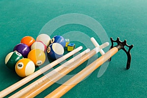 Closeup of snooker billards balls, chalk, cue and extender stick