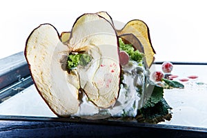 Closeup soft white cheese decorated dried apple and green salad