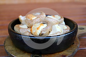 Closeup Soko Ketze or Georgian Stuffed Mushrooms with Sulguni Cheese in a Clay Dish