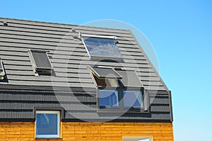 Closeup of Solar Water Panel Heating, Dormers, Solar Panels, Skylights. Passive House Building Concept. photo