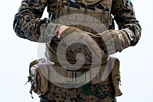 Closeup of soldier hands putting protective battle gloves