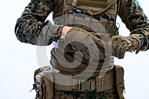 Closeup of soldier hands putting protective battle gloves