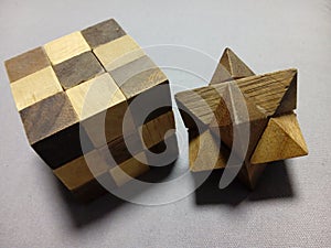 Closeup of a solved cube and star wooden puzzle on a gray surface