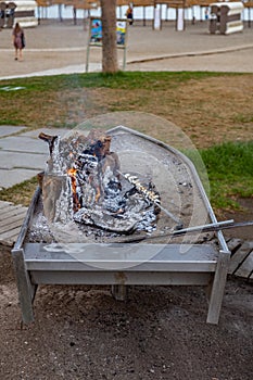 Closeup of some espetos prepared on skewers and open flame on fireplace with olive trees wood on the beach.