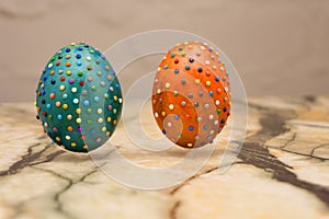 Closeup of some homemade easter eggs, made by myself by gluing some pieces of different papers, drying attached to wooden sticks .