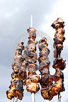 Closeup of some meat skewers being grilled in a barbecue