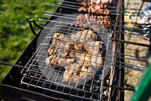 Closeup of some meat skewers being grilled in a barbecue. Grilling marinated shashlik on a grill.