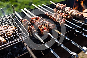 Closeup of some meat skewers being grilled in a barbecue. Outdoors