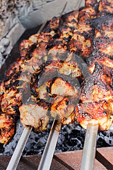 Closeup of some meat skewers being grilled in a barbecue