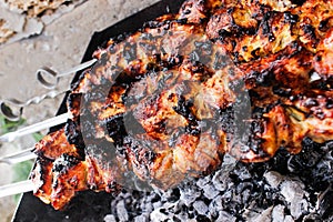 Closeup of some meat skewers being grilled in a barbecue