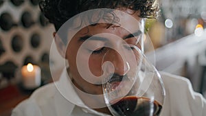 Closeup sommelier sniffing wine from elegant glass. Winery expert tasting smell