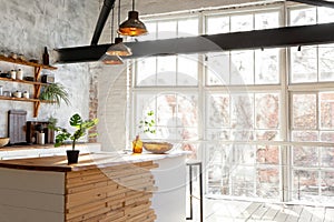Closeup of a spacious loft industrial open space kitchen studio interior with big windows and sunlight in the morning