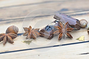 spices and chocolate with nuts and christmas confetti on a wooden table