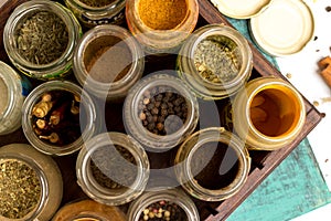 Closeup spices and herbs jars. Food, cuisine ingredients. Wooden box.